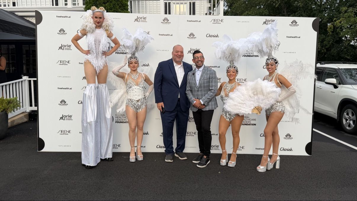 Performers in white and silver costumes greeting guests at an outdoor event
