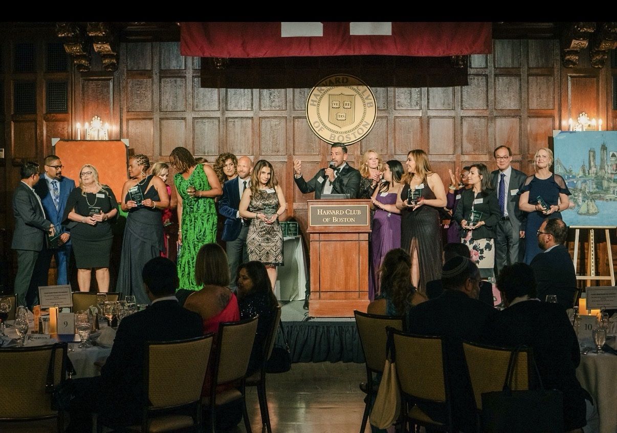 A speaker addressing a full room at a formal gala